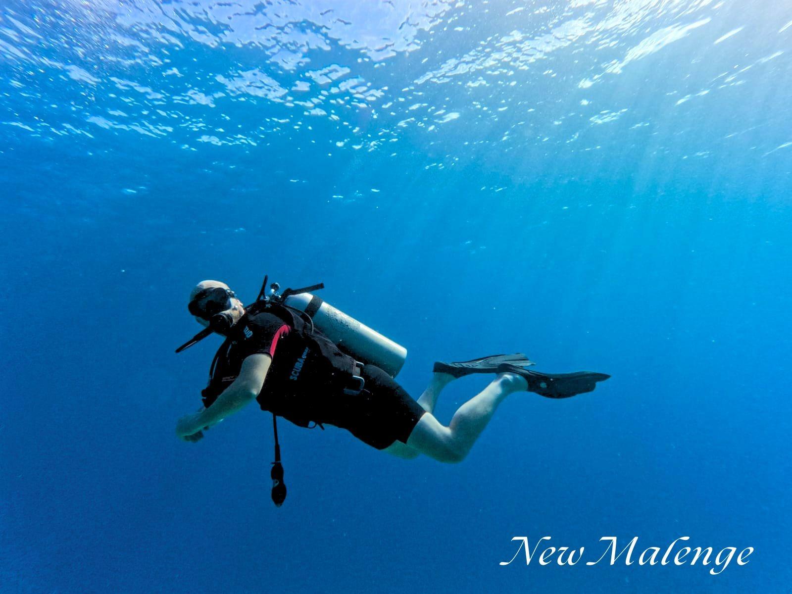 Malenge Dive Resort – diver in blue water off Malenge